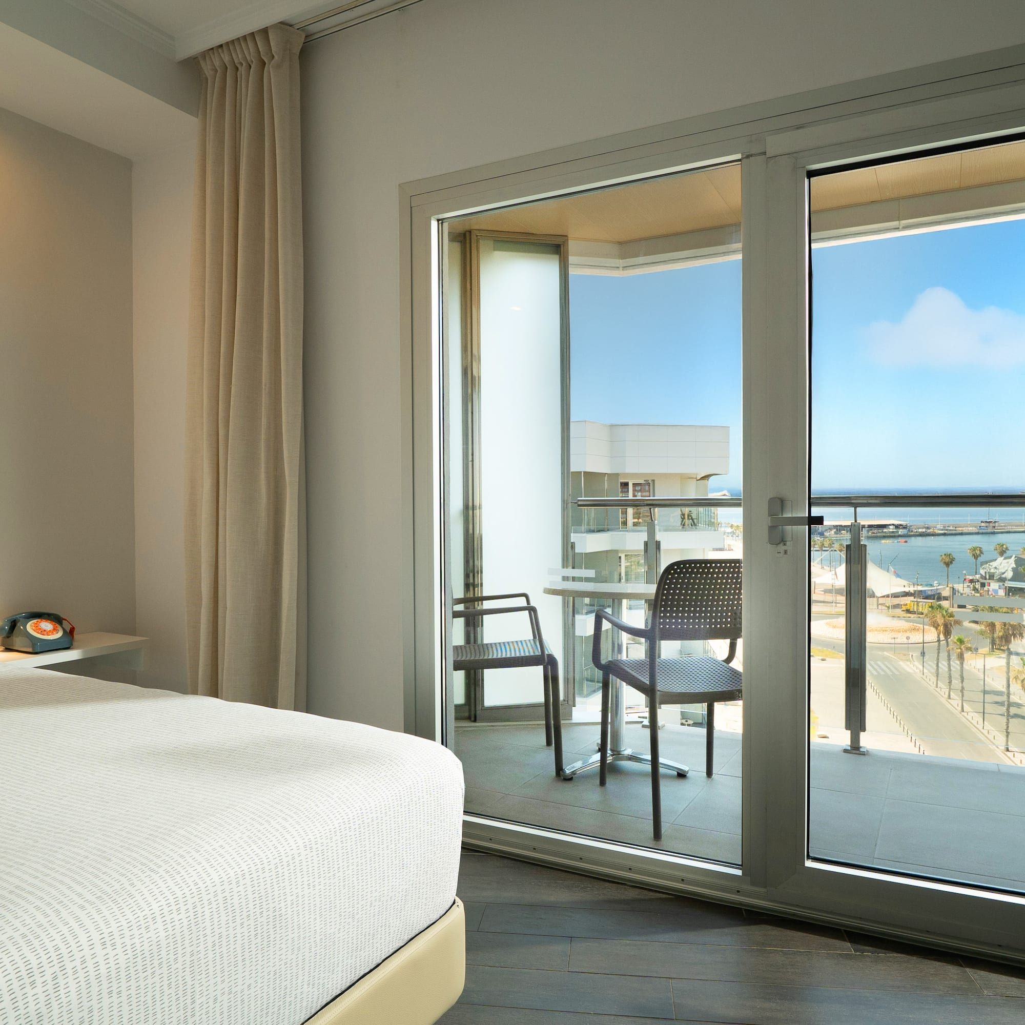 a bedroom with a glass door and a view of the ocean