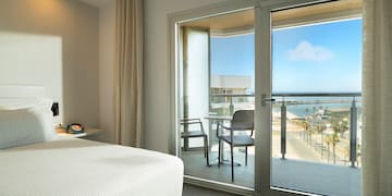 a bedroom with a glass door and a view of the ocean