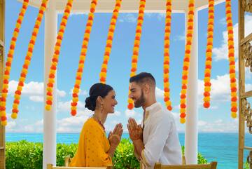 a man and woman in traditional attire holding hands together