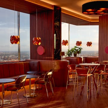 a room with tables and chairs and a view of a city