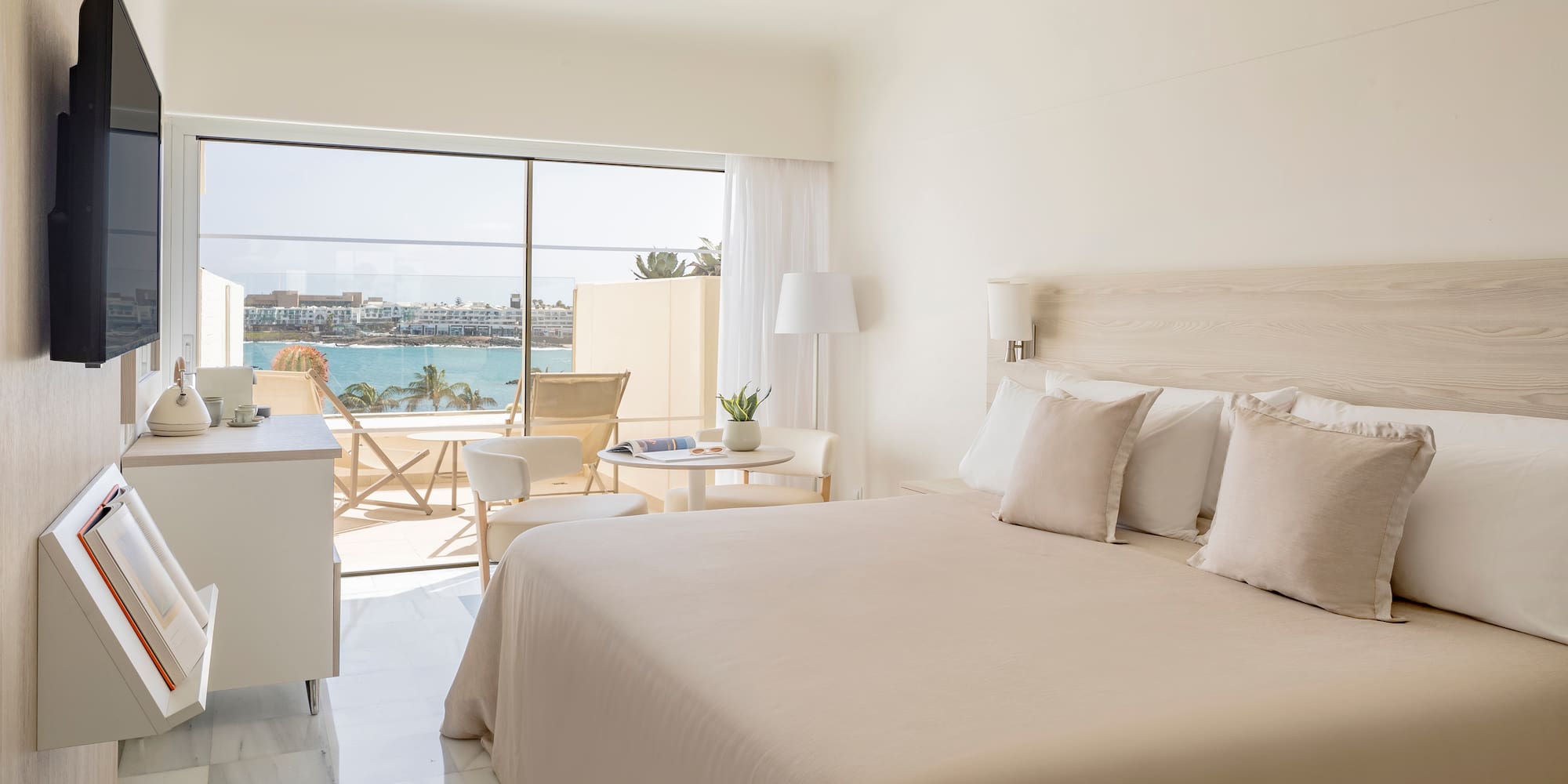 a bedroom with a large window overlooking the water