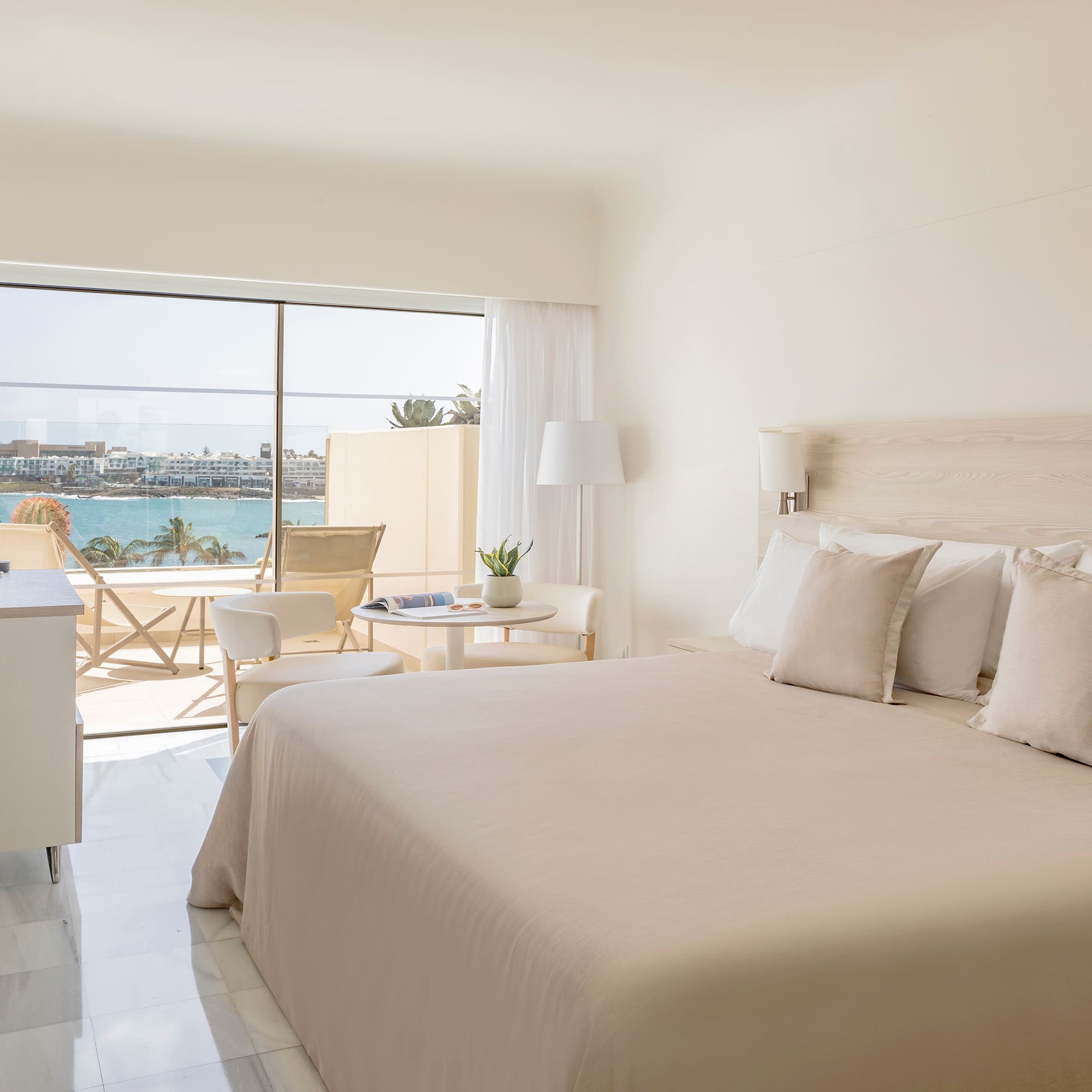 a bedroom with a large window overlooking the water