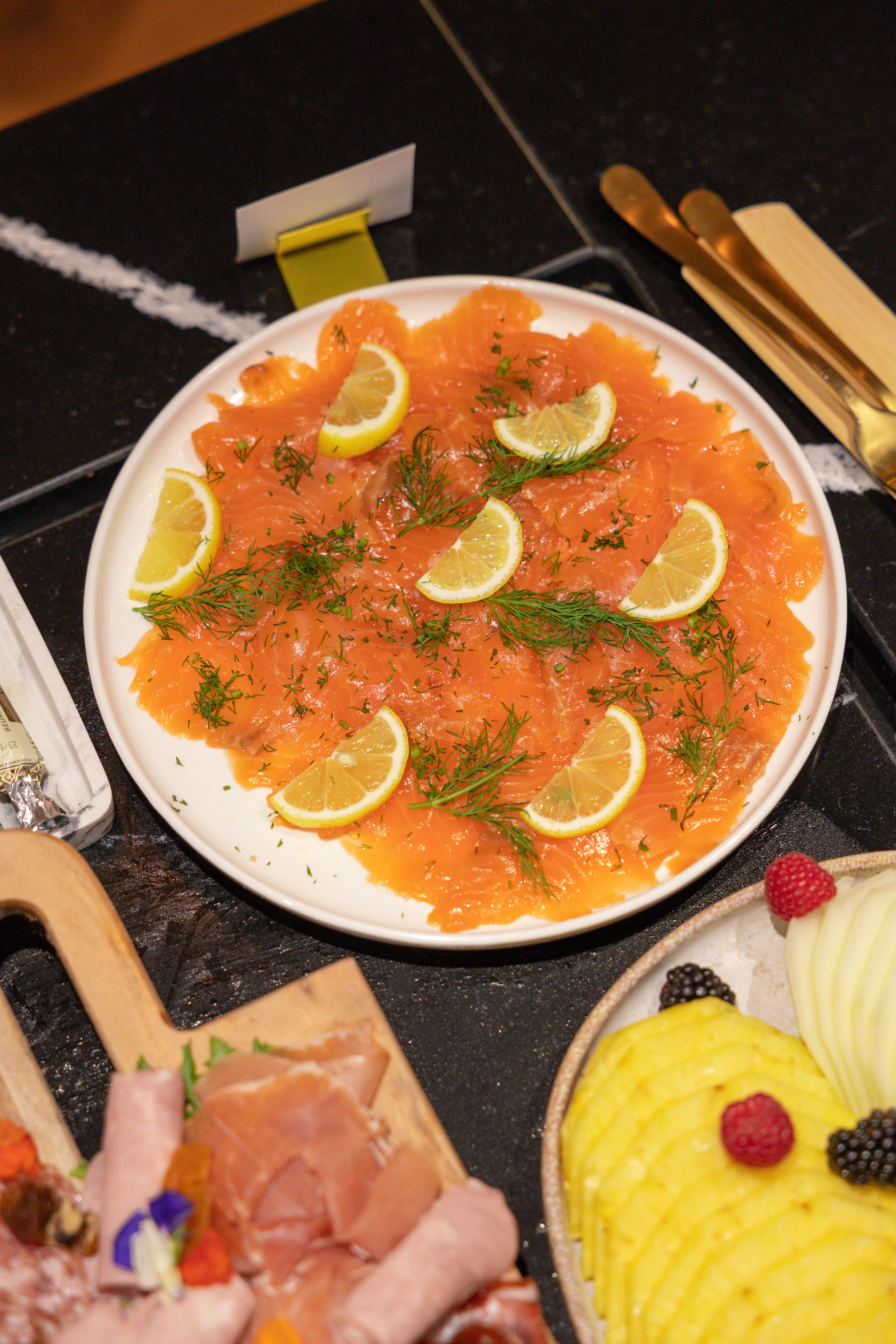 Smoked salmon with fresh lemon and dill on a buffet platter.