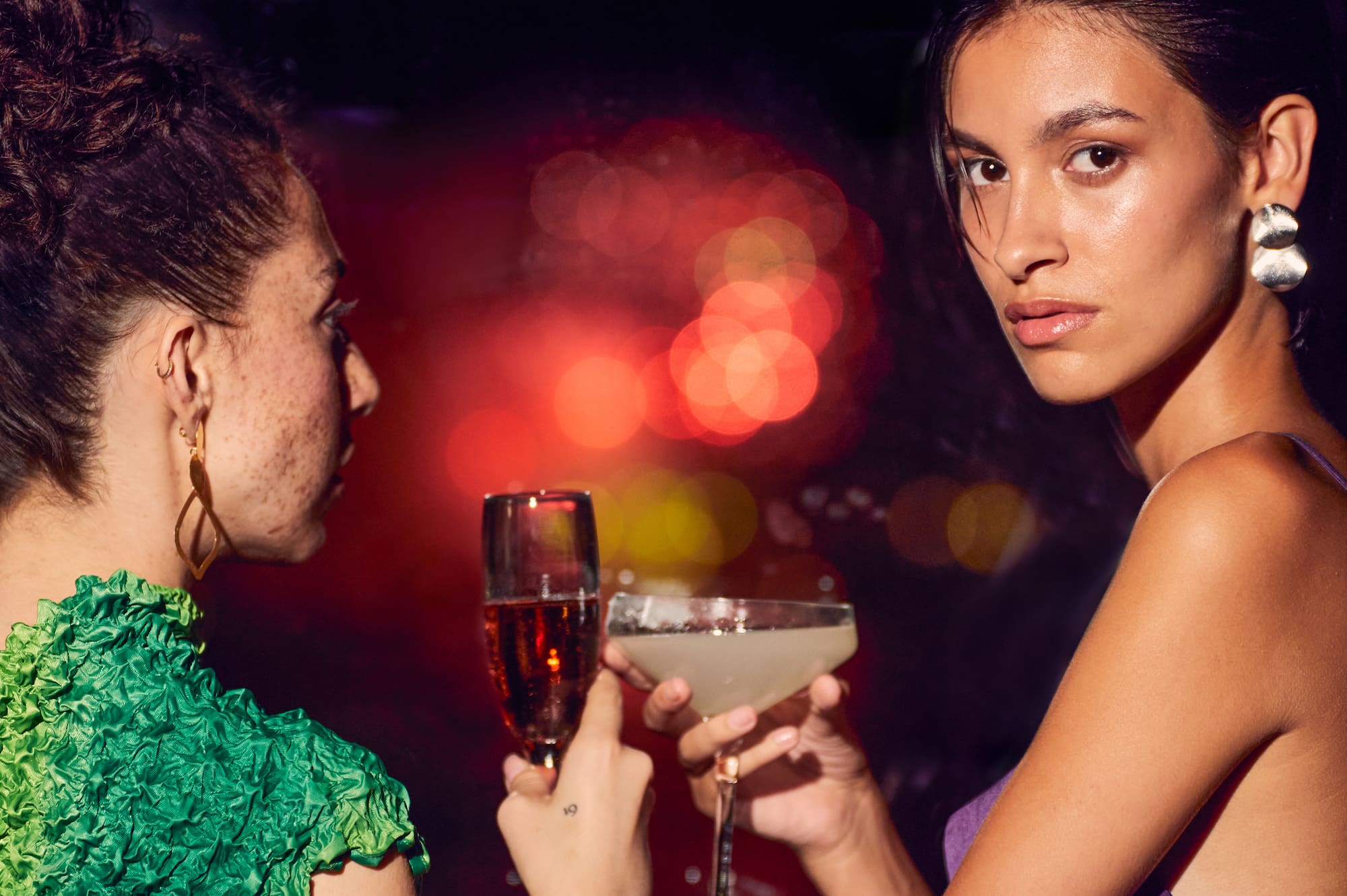 two women holding drinks
