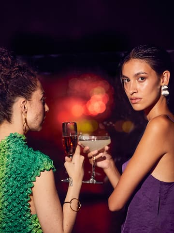 two women holding drinks