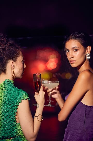 two women holding drinks