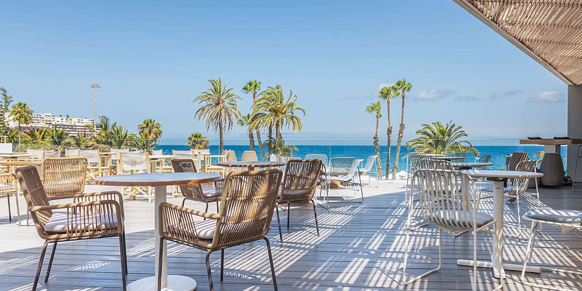 a patio with tables and chairs and palm trees