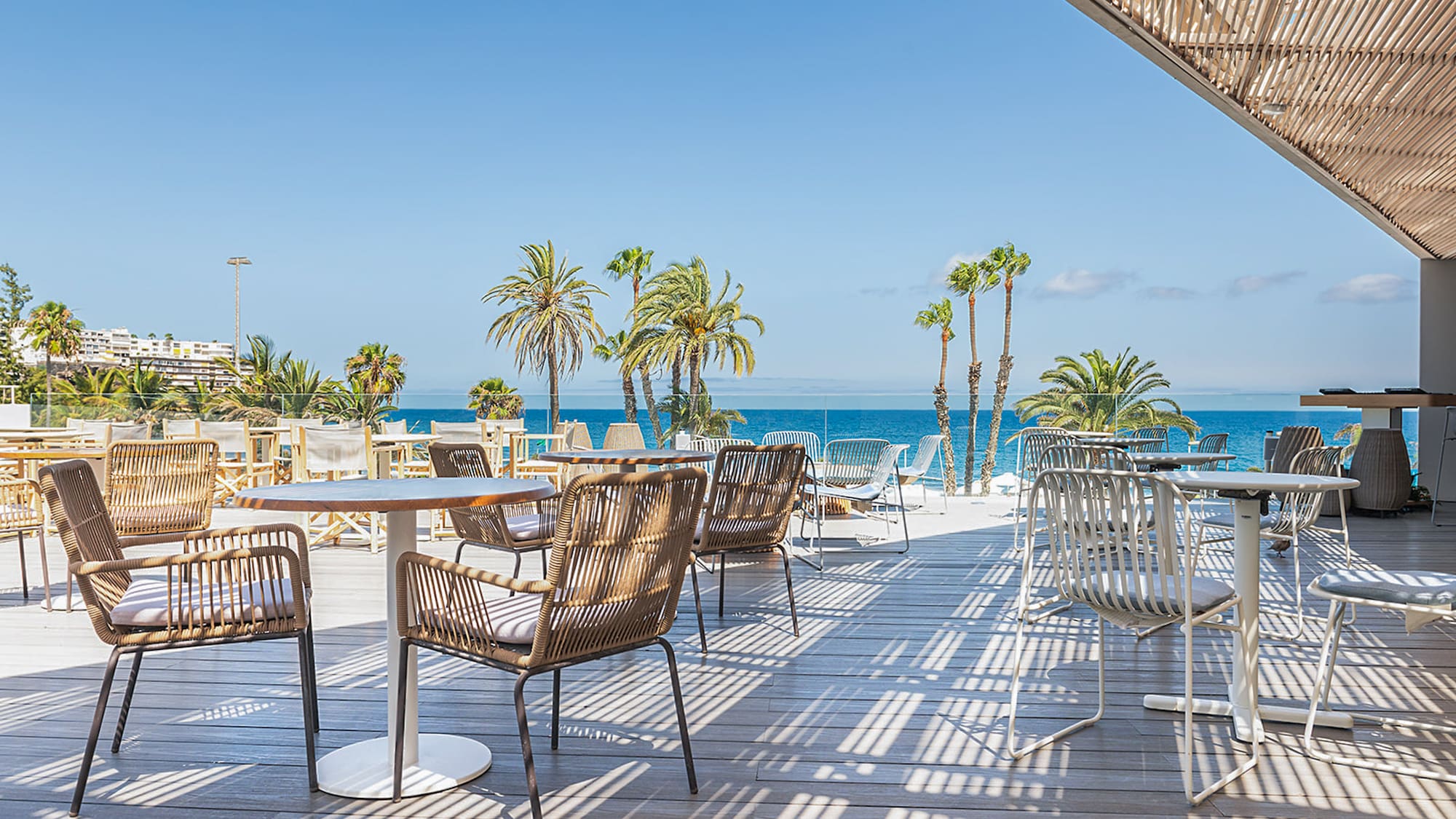 a patio with tables and chairs and palm trees