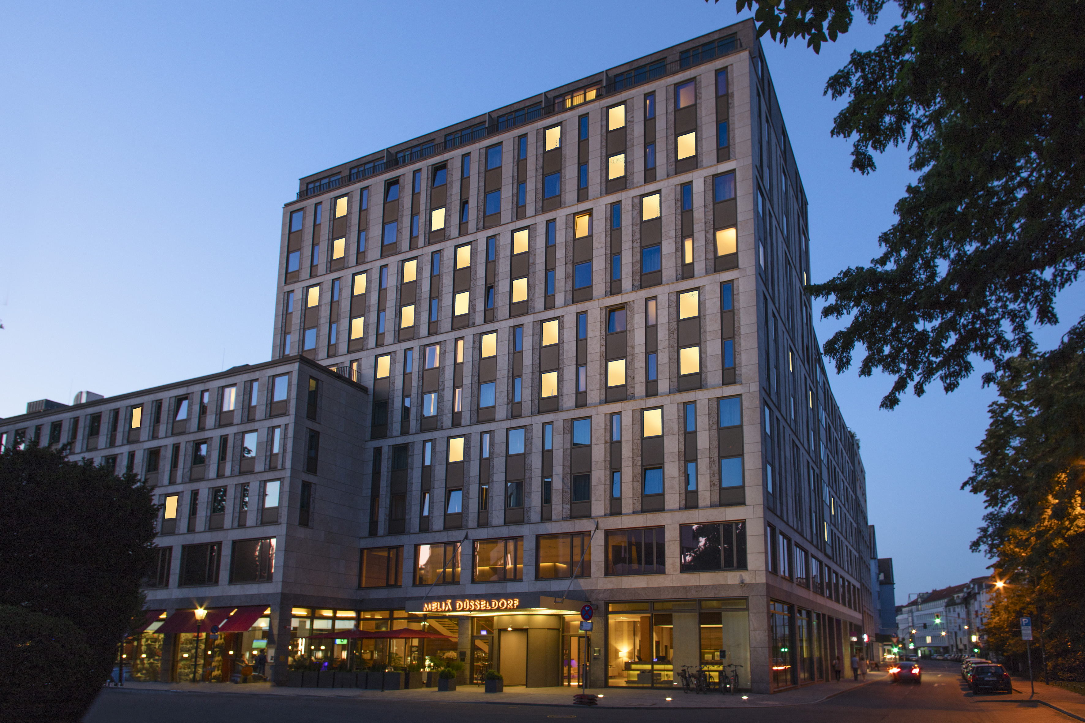 Meliá Düsseldorf hotel, modern building with illuminated windows at night.