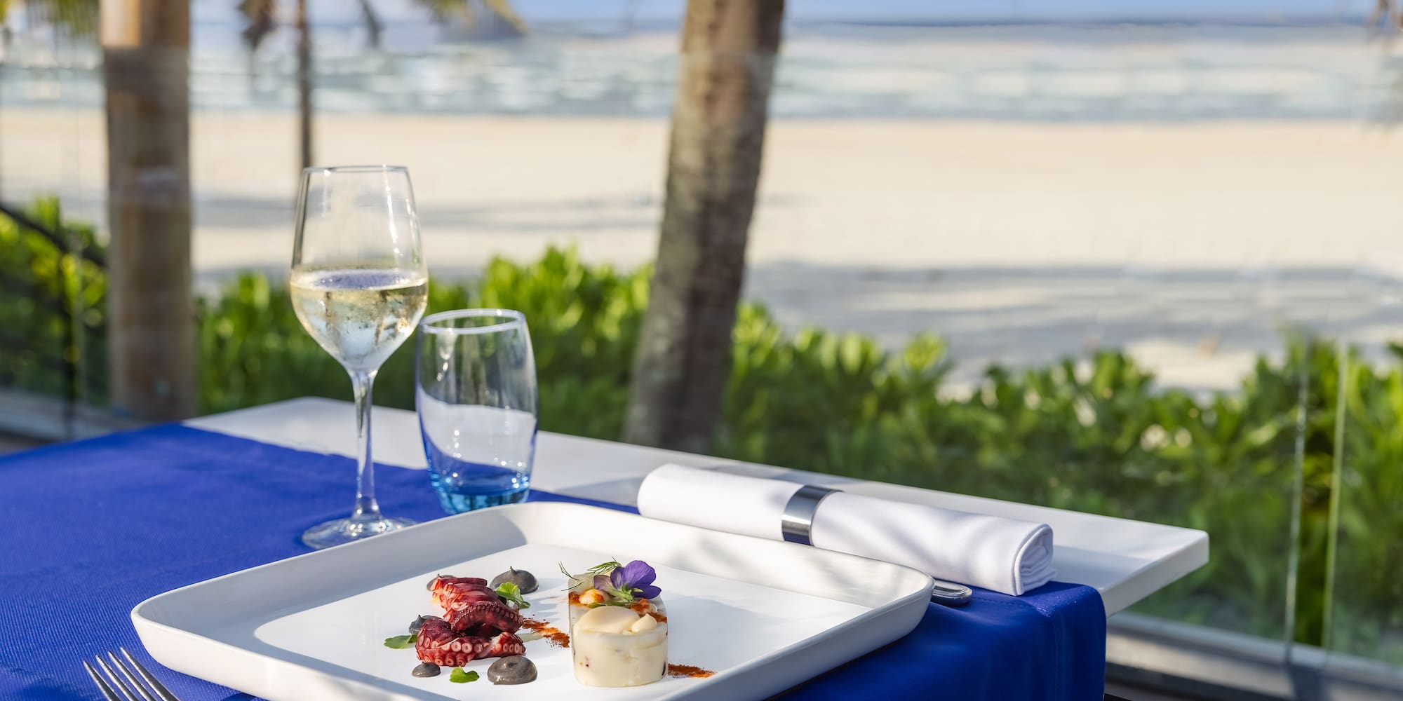 a plate of food on a table with a glass of wine