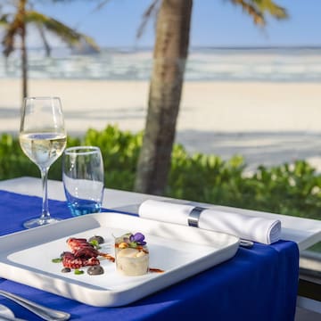 a plate of food on a table with a glass of wine