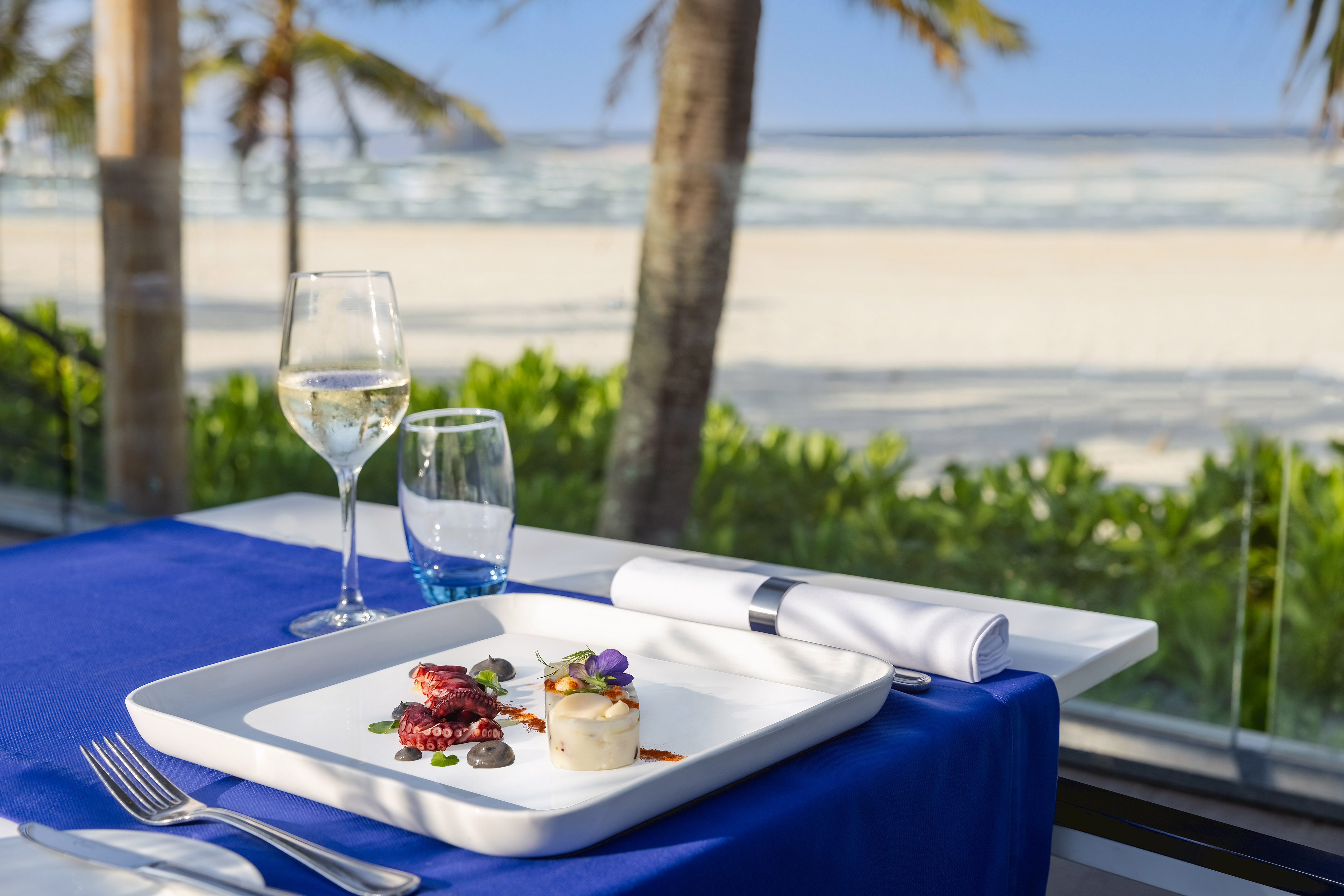 a plate of food on a table with a glass of wine