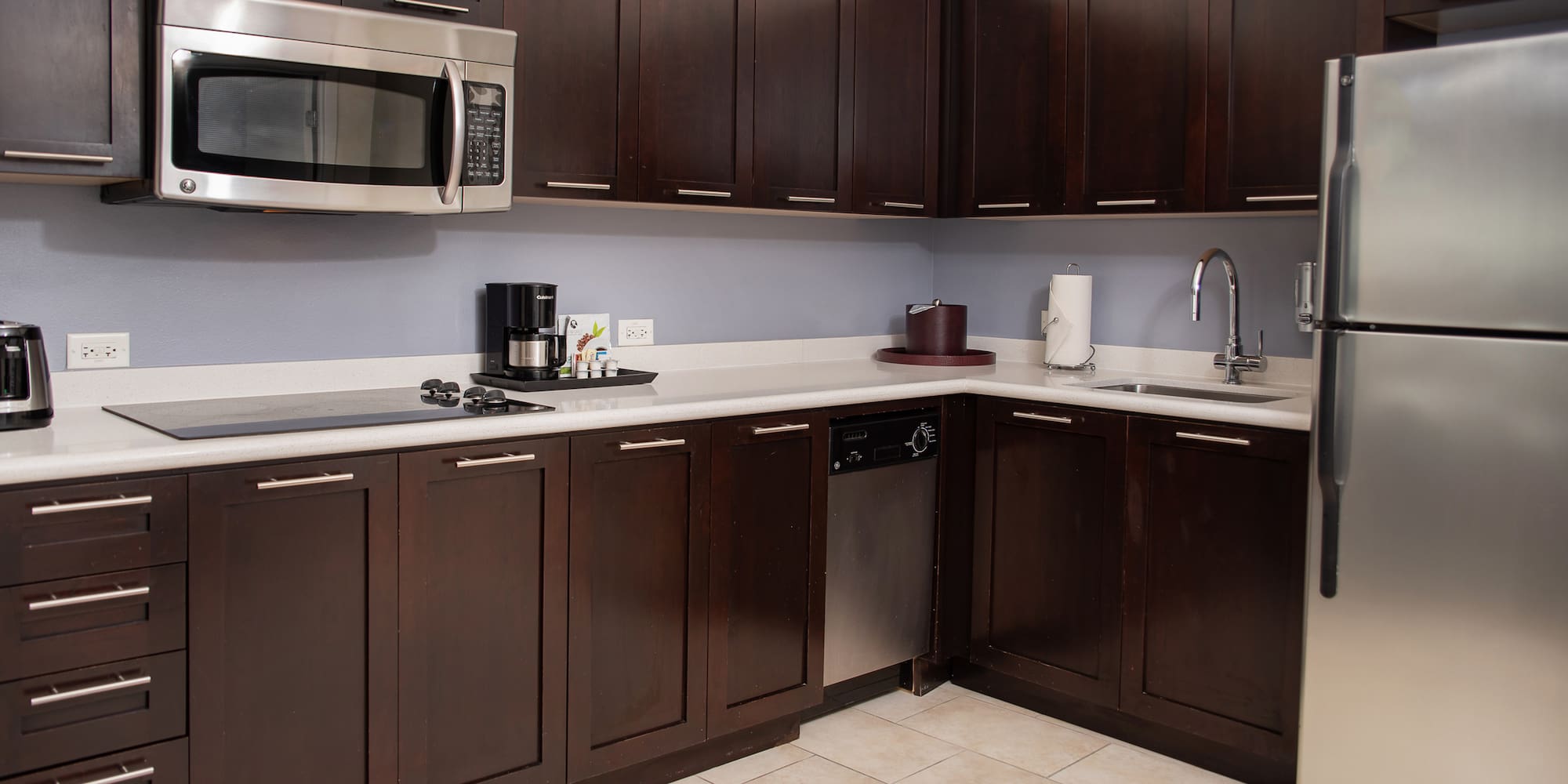 a kitchen with dark wood cabinets and a microwave