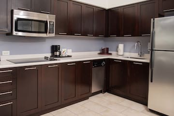 a kitchen with dark wood cabinets and a microwave