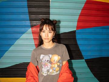 a woman standing in front of a colorful wall