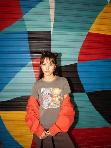a woman standing in front of a colorful wall