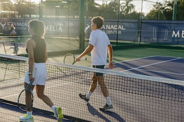 a group of people on a tennis court