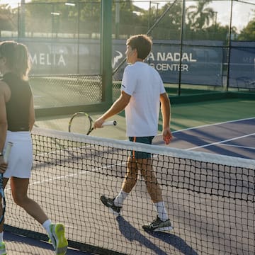 a group of people on a tennis court