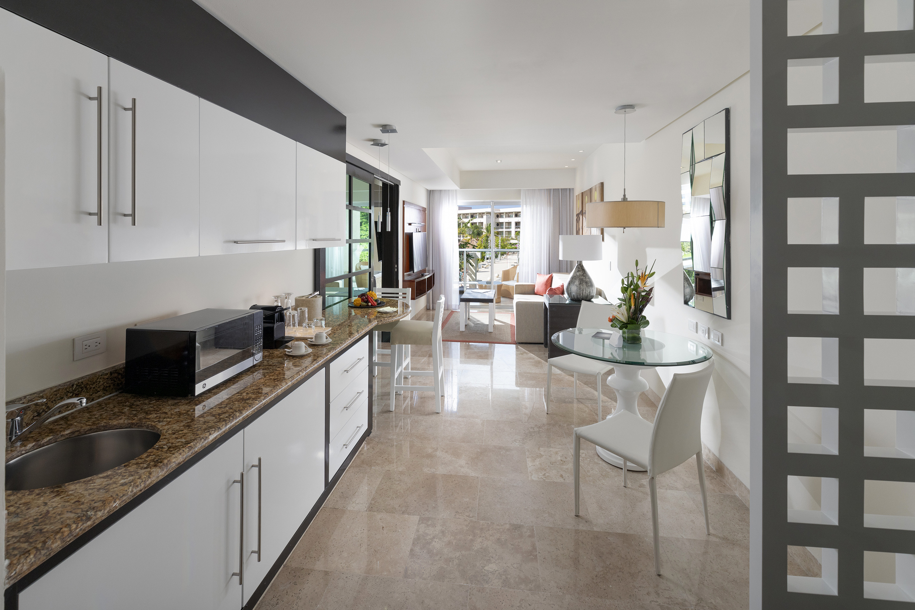 Modern kitchen, dining, and living area in a contemporary open-concept suite.