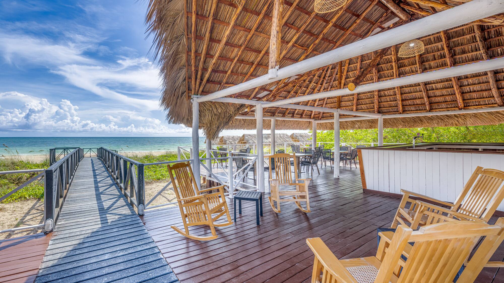 a deck with chairs and a thatched roof