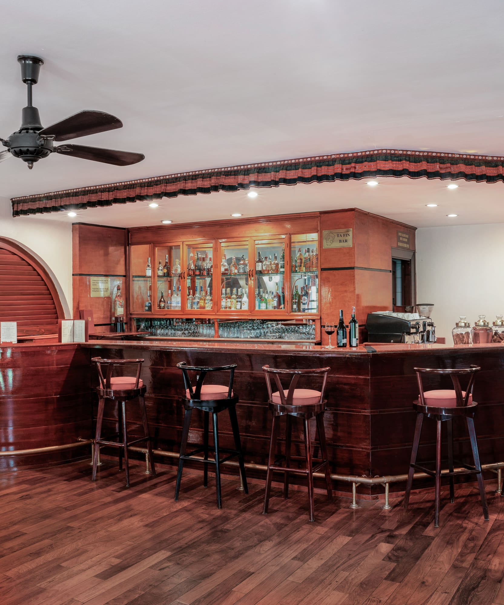 a bar with stools and a ceiling fan