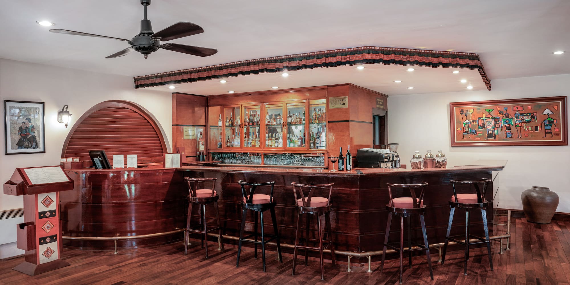 a bar with stools and a ceiling fan