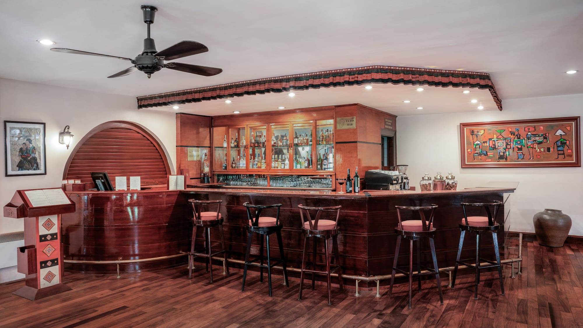 a bar with stools and a ceiling fan