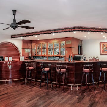a bar with stools and a ceiling fan