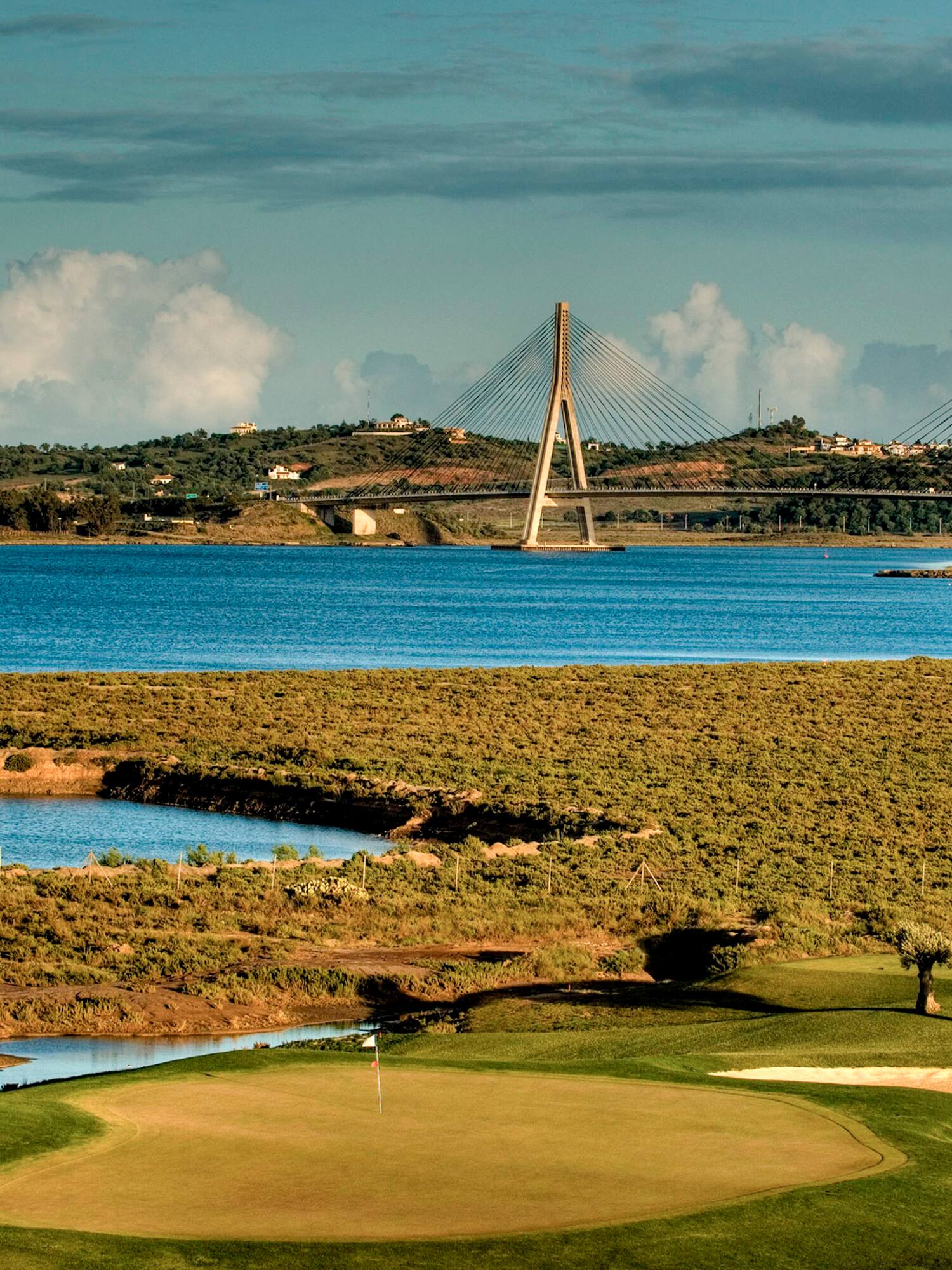 a golf course with a bridge over water