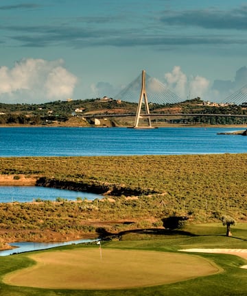 a golf course with a bridge over water
