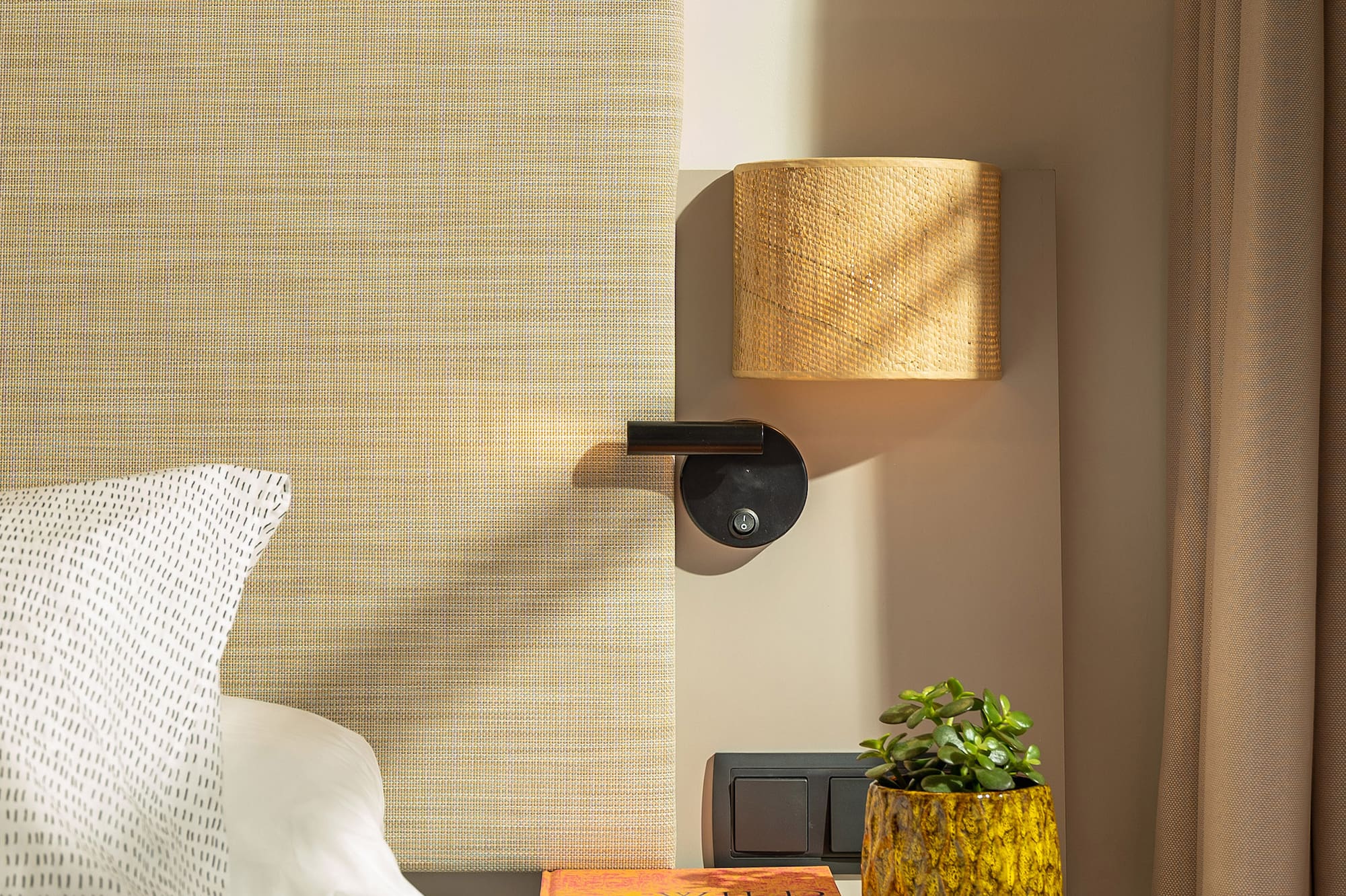 a bed with a plant on a table