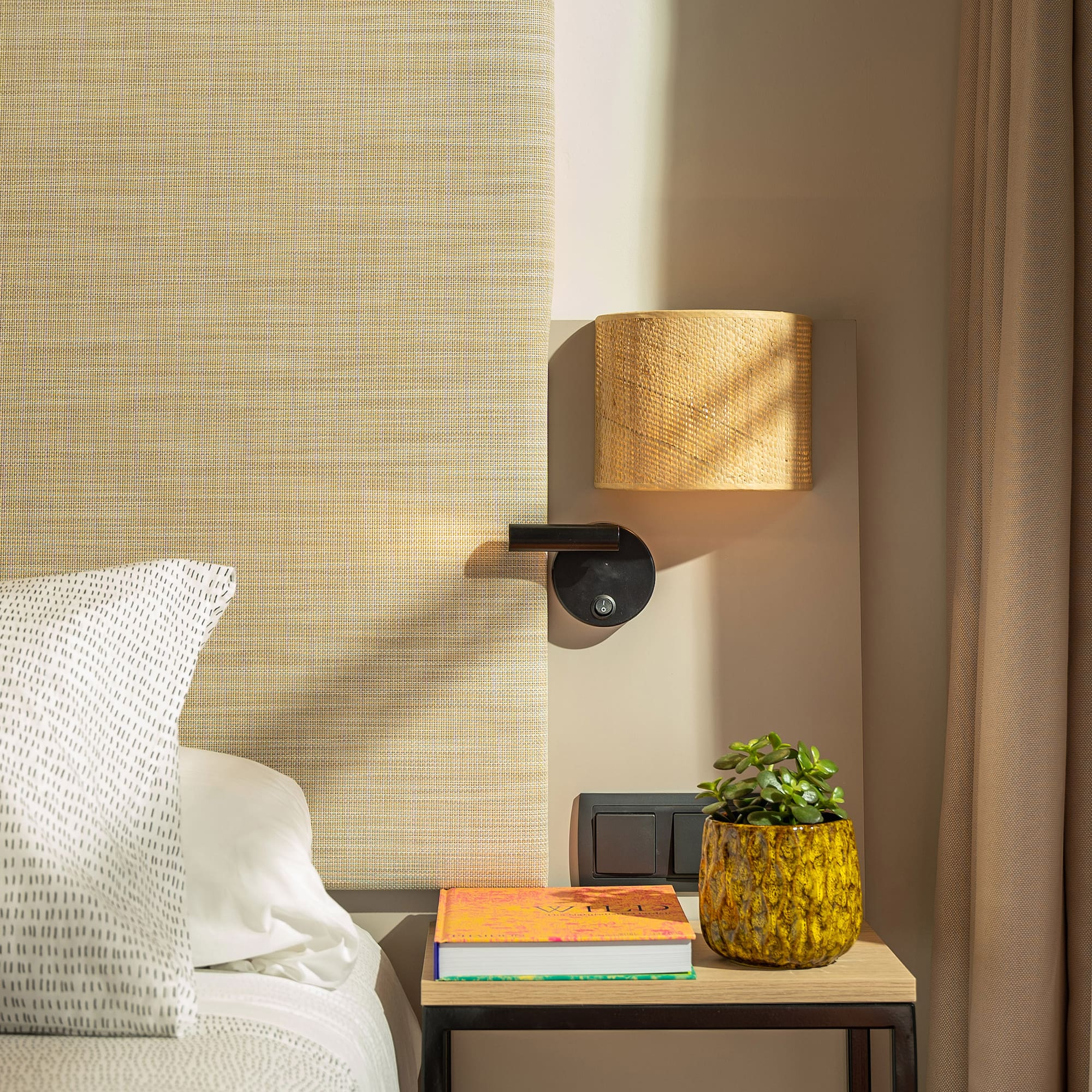 a bed with a plant on a table