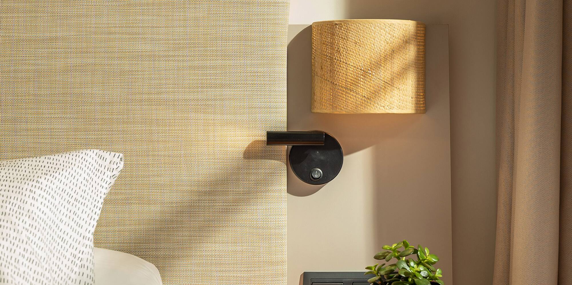 a bed with a plant on a table