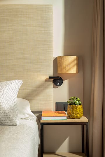a bed with a plant on a table