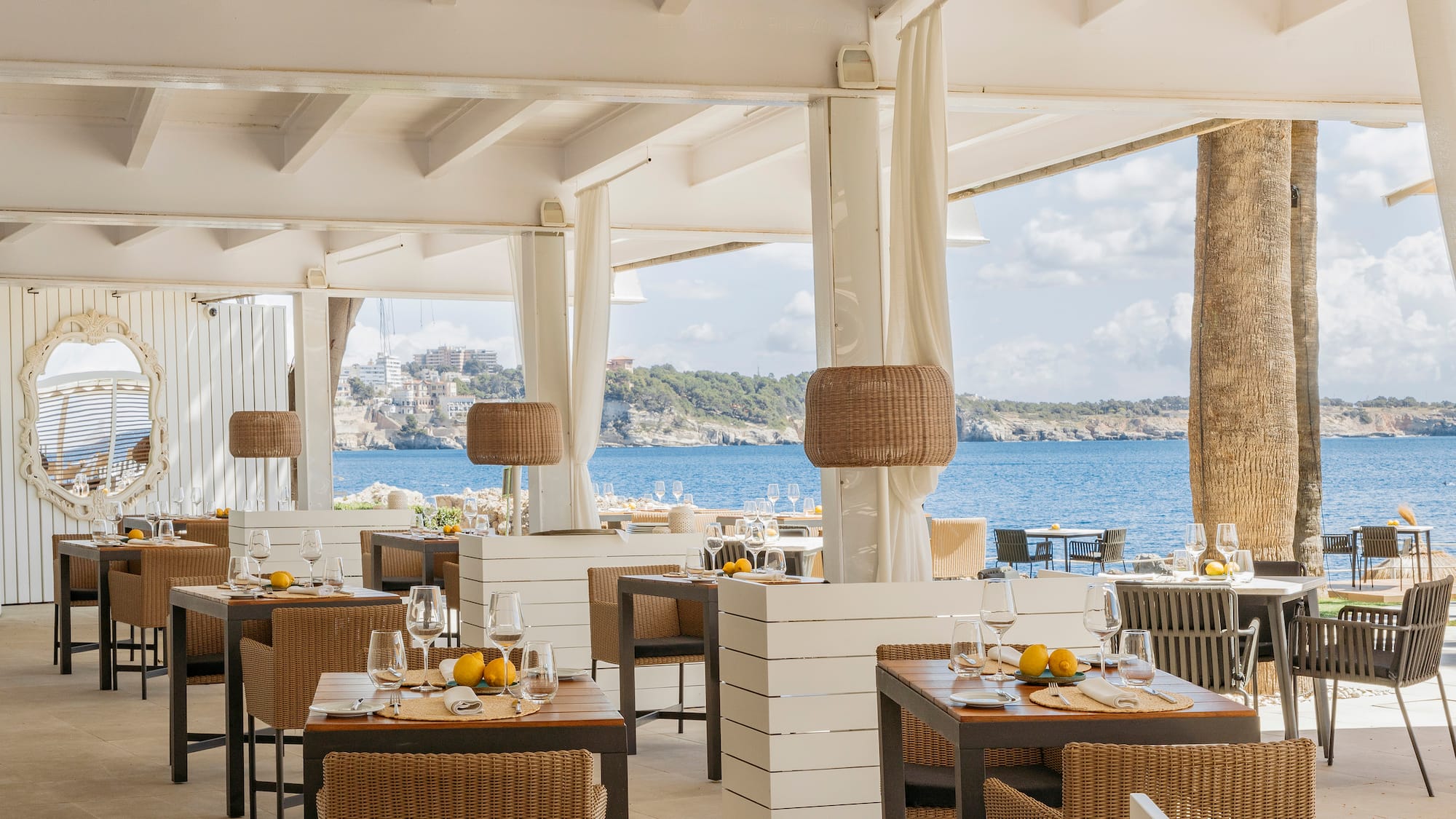 a restaurant with tables and chairs and a view of the ocean