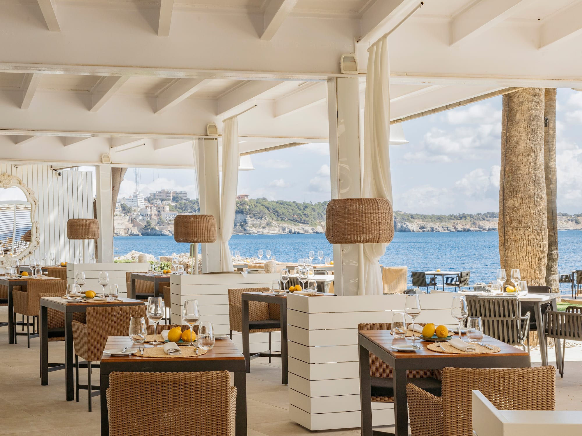 a restaurant with tables and chairs and a view of the ocean