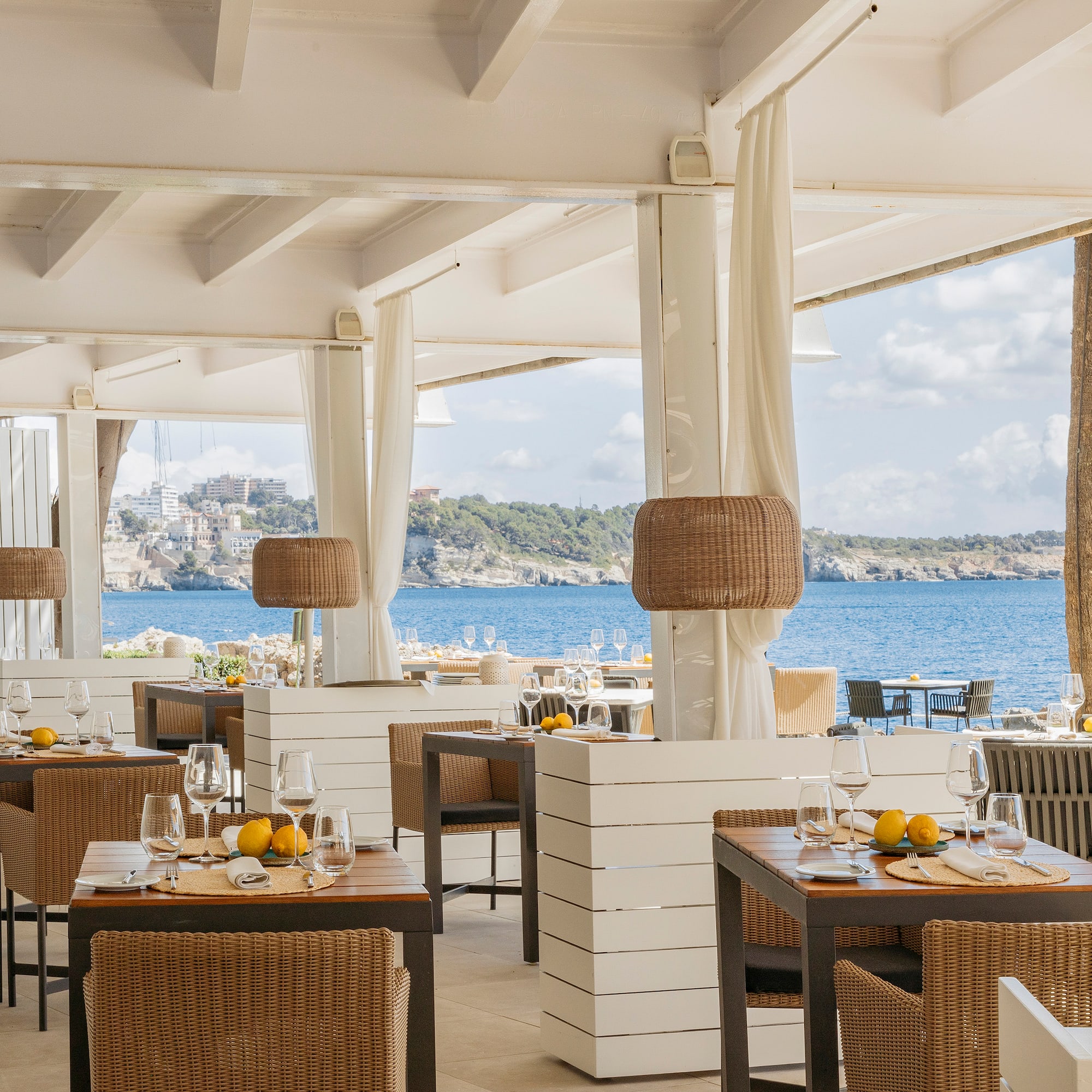a restaurant with tables and chairs and a view of the ocean