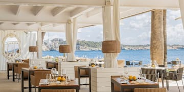 a restaurant with tables and chairs and a view of the ocean