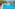 Resort swimming pool with blue lounge chairs, palm trees, and hotel buildings.