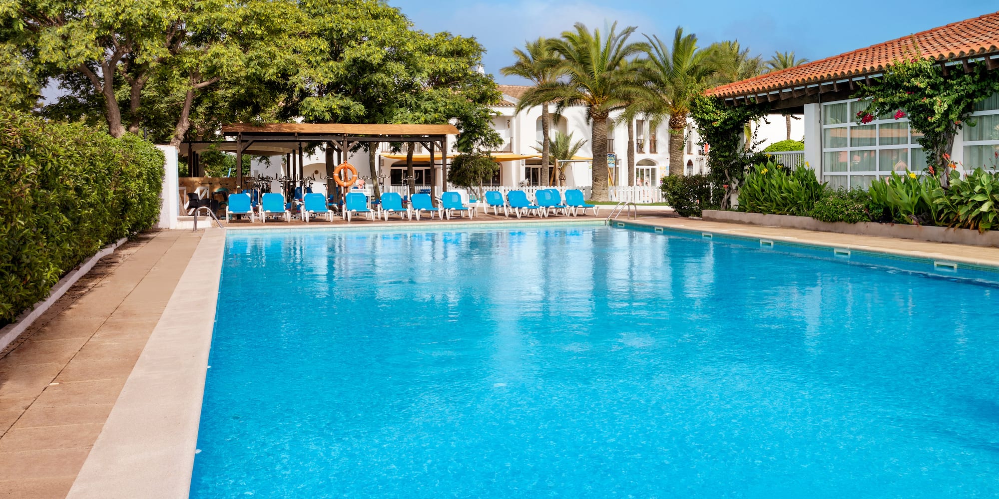 a pool with chairs and trees