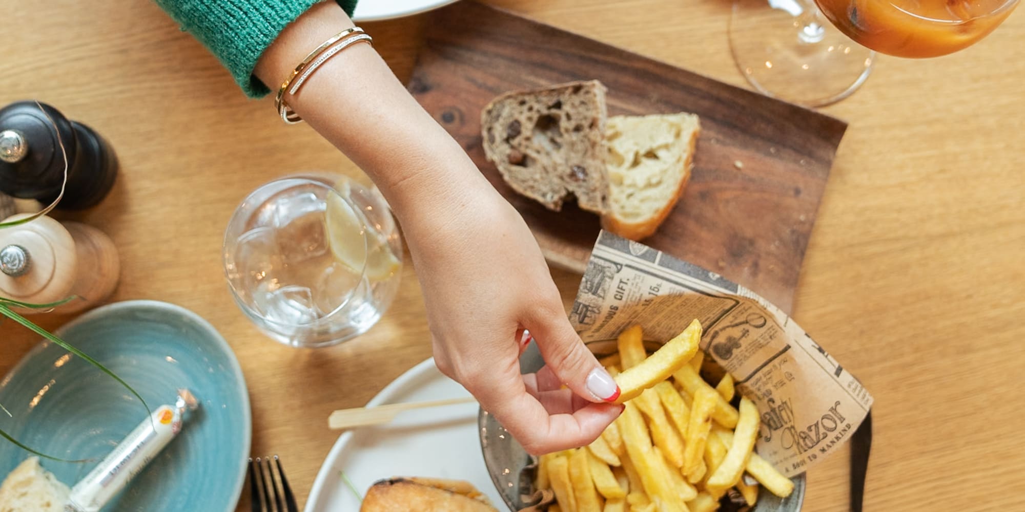 a person holding a sandwich and french fries