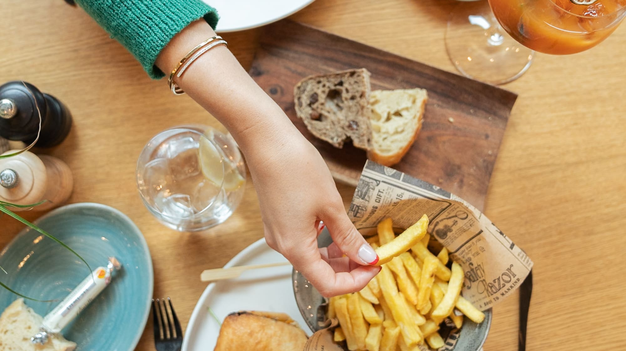 a person holding a sandwich and french fries