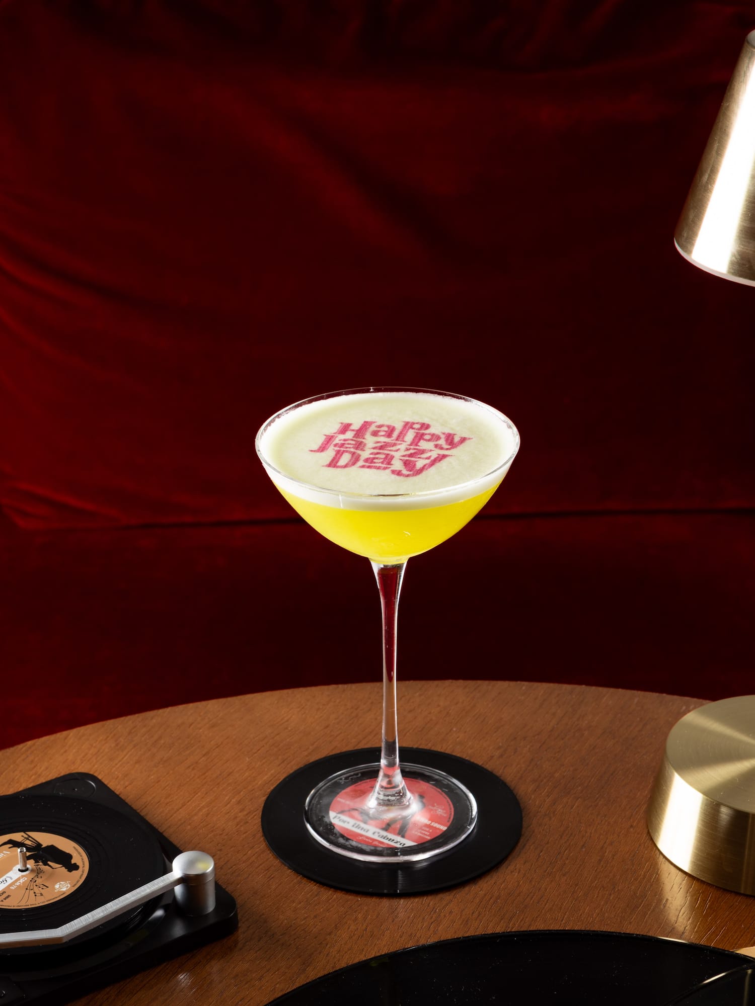 a glass of yellow liquid on a table