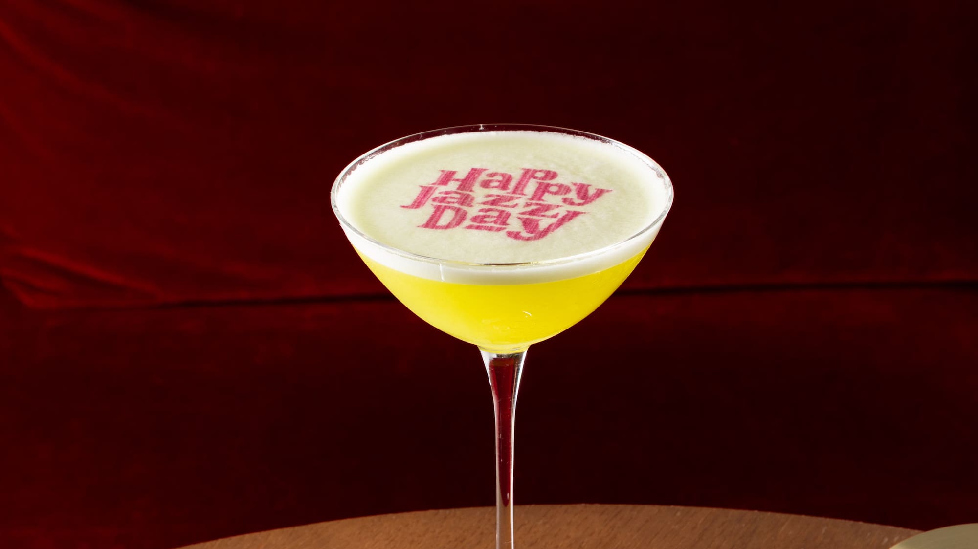 a glass of yellow liquid on a table