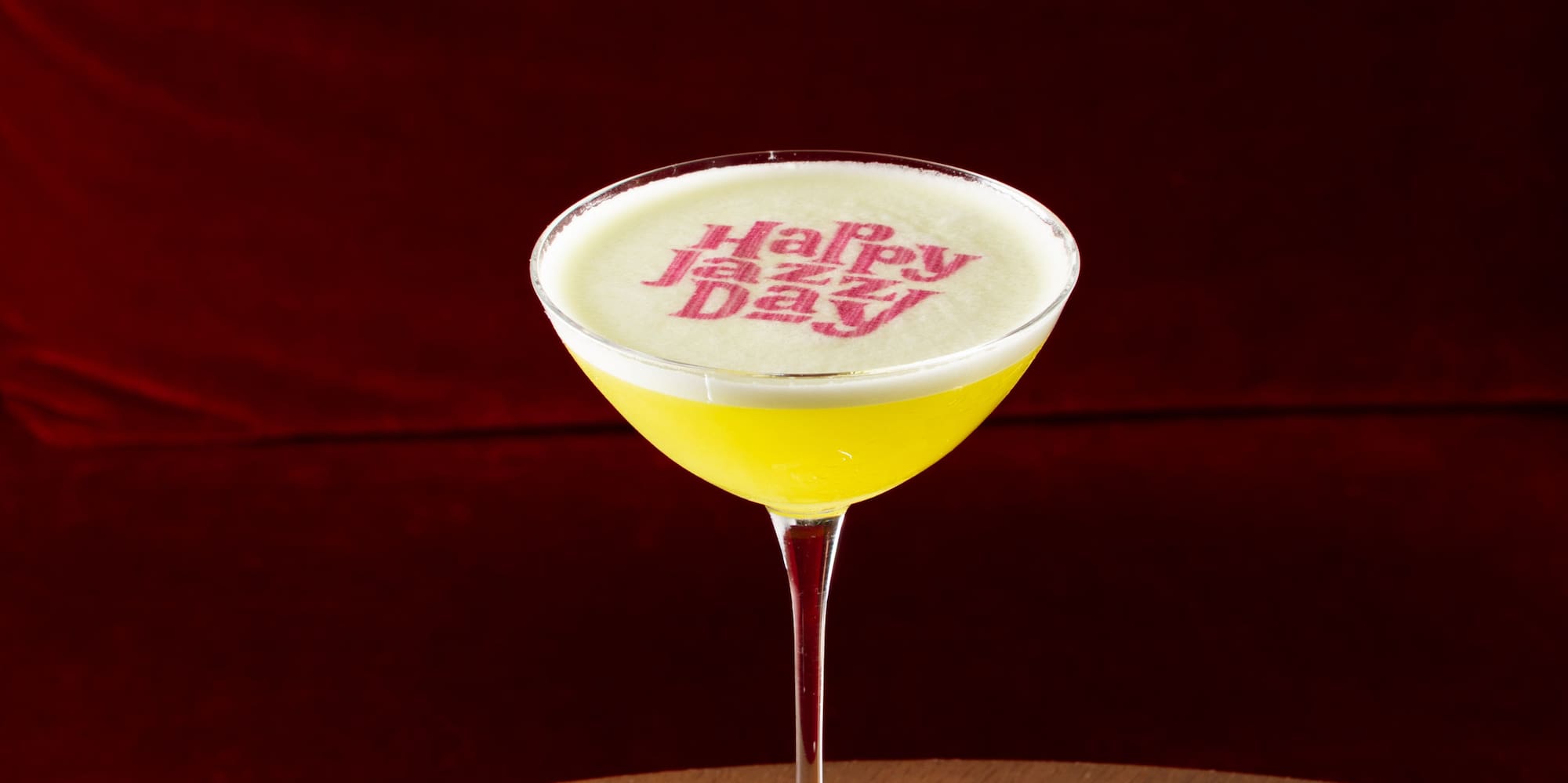 a glass of yellow liquid on a table