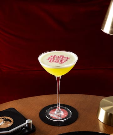 a glass of yellow liquid on a table