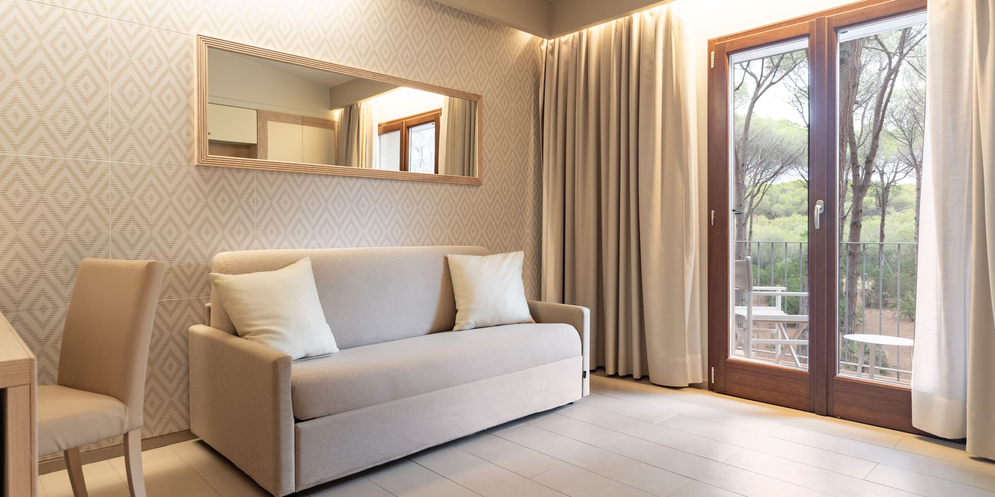 a couch in a room with a door and a mirror