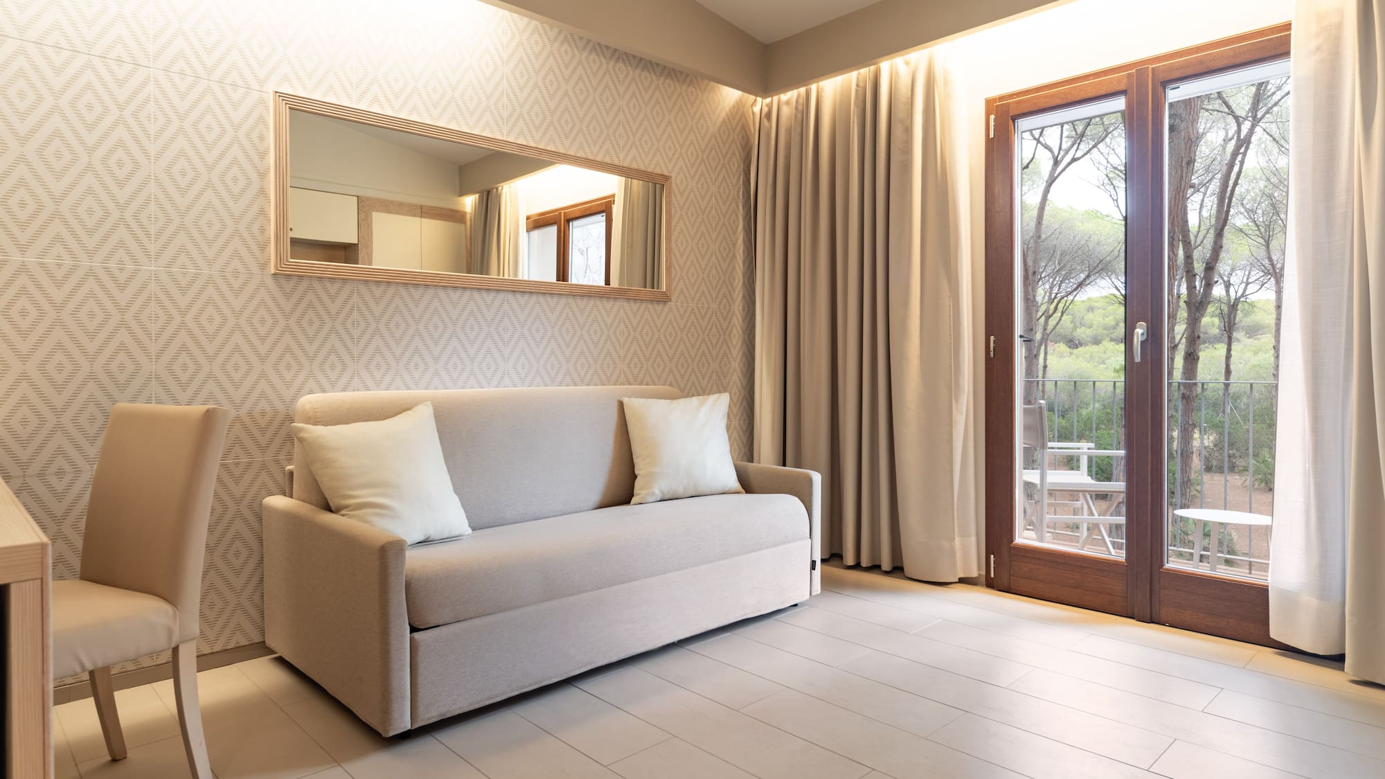 Modern living area with neutral sofa, mirror, and balcony view.
