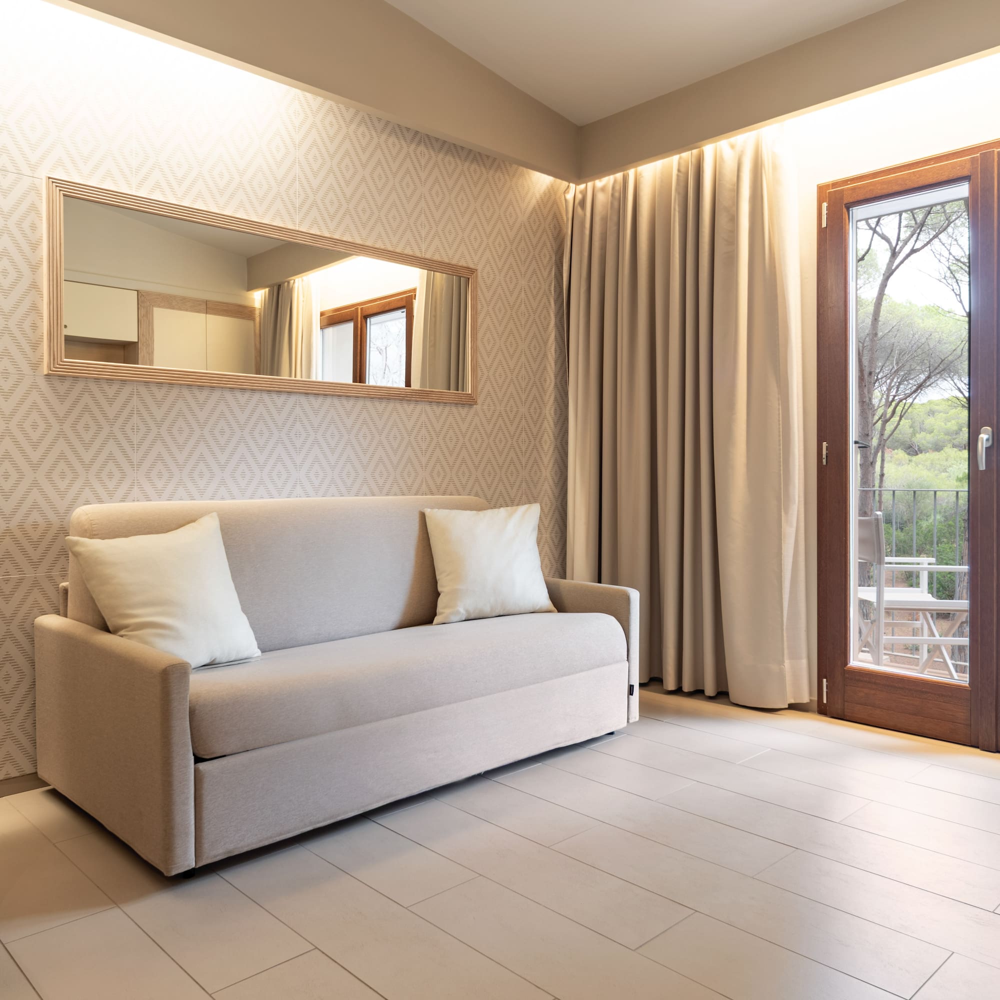 a couch in a room with a door and a mirror