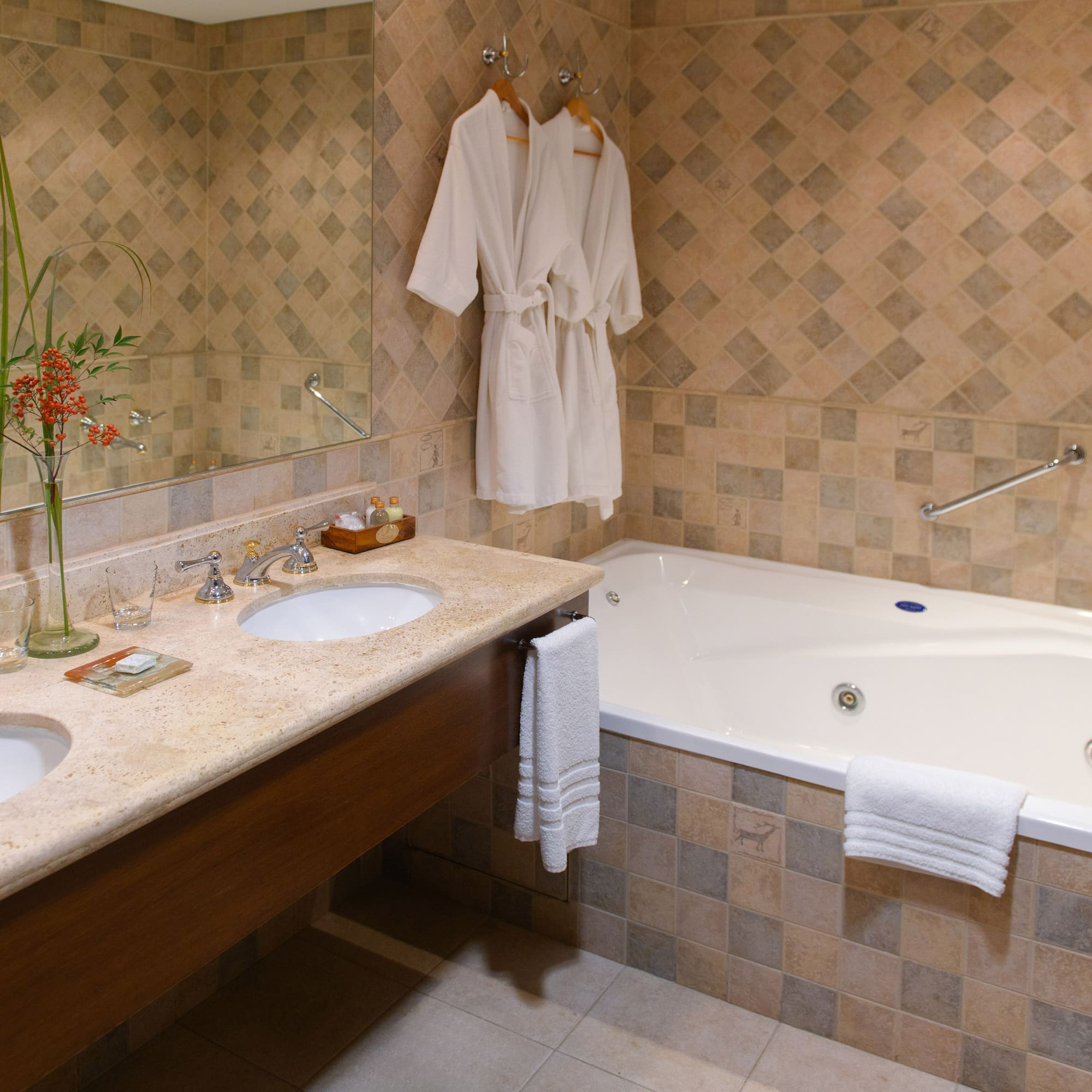 a bathroom with a bathtub and bathrobes